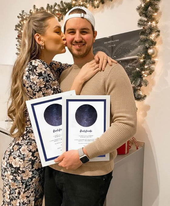 Coppia con due certificati stellari personalizzati davanti alle decorazioni natalizie