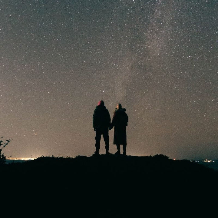Due persone osservano insieme un cielo pieno di stelle